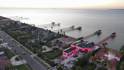 Red Lighting Villa in Apollo beach with private jetty during sunset. Illuminated mansion in Florida. Aerial top down approaching shot.