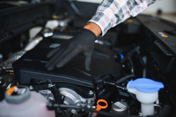 Auto mechanic performing a routine service inspection in a service garage
