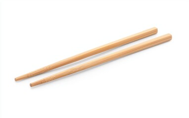 A pair of chopsticks made of natural bamboo with a smooth finish lying parallel on a solid white background, single object