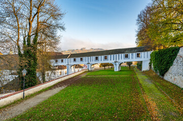 Fototapeta premium Covered bridge from Cesky Krumlov Castle leading into the park, arching over a narrow alley. The historic structure adds a touch of charm to the peaceful surroundings
