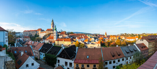 Naklejka premium Panoramic view of Cesky Krumlov, featuring the historic castle tower and the church of St. John of Nepomuk. The medieval town's charm is beautifully captured on a sunny day