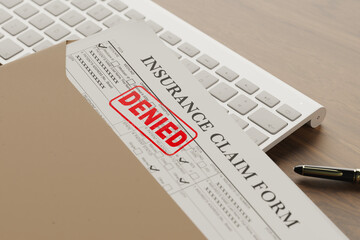 Document with denied stamp put on the wooden table.deneid health insurance application form on the...