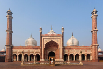 Fototapeta premium The iconic Jama Masjid in Delhi, India, with its grand architecture, three domes, and two towering minarets, captured under a clear blue sky