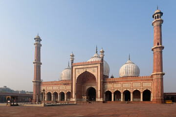 Fototapeta premium Majestic view of Jama Masjid in Delhi, India, showcasing its grand architecture with towering minarets and domes under a clear blue sky
