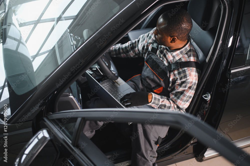 Poster Black auto mechanic running diagnostic on laptop while analyzing engine problems in a workshop