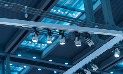 LED spotlights on rails under the ceiling in a modern warehouse, shopping center building, office...