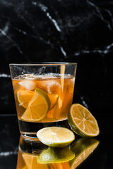 whiskey in a glass with ice and lime on a black mirror background, place for drinks, alcohol, alcoholic cocktails, exquisite whiskey cocktail