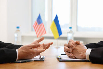 Diplomats negotiating during meeting at table indoors, closeup