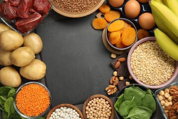 Diet plan for anemia. Different products rich in iron and slate board on table, flat lay. Space for text