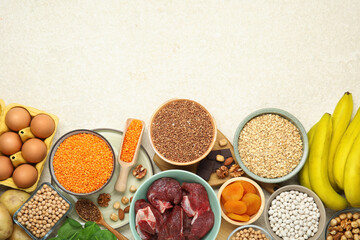 Different products rich in iron on light table, flat lay with space for text. Anemia diet plan