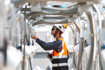 Male plumber working and checks water pipes system at rooftop of building. Asian male plumber...