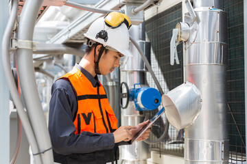 Male plumber working and checks water pipes system at rooftop of building. Asian male plumber maintenance water pipes network system on building rooftop