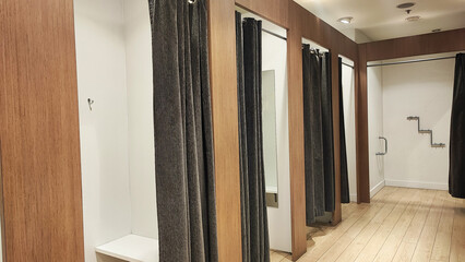 Empty changing rooms with wooden doors and white walls. Dressing rooms of a clothing store with no people. Shopping concept.