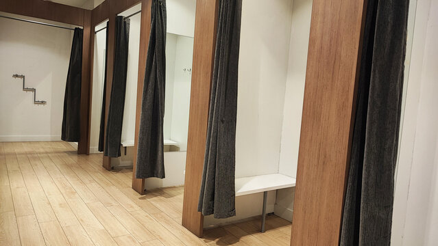 Empty changing rooms with wooden doors and white walls. Dressing rooms of a clothing store with no people. Shopping concept.