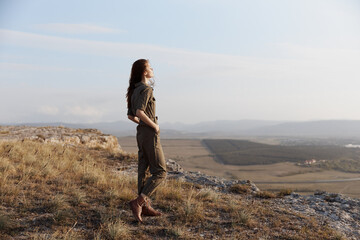 Naklejka premium Woman standing on top of hill contemplating majestic view of valley and distant mountains while traveling in nature