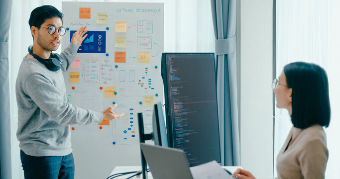 Group adult Asia male female software developers mentor leader manager talk strategy plan to executive write prompt AI bot IT app program nomad, video game, data center. Whiteboard slideshow code.