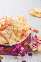 Angel wings or sfrappole. Traditional sweet crisp pastry deep-fried and sprinkled with powdered sugar. Carnival food tradition.  Vertical image.