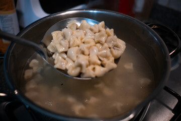 Traditional Turkish dish manti is being boiled in a pot.