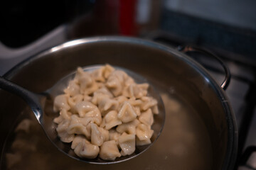Traditional Turkish dish manti is being boiled in a pot.