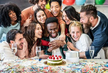 Diverse friends united in birthday sparkly wine and cake - Group of young people celebrating a birthday in the office - Life style concept with multi ethnic men and women enjoying at home bday party