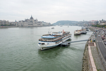 Danube River in Budapest, Hungary &ndash; Scenic View of Hungarian Parliament Building with Docked Riverboats and Cityscape. High quality photography