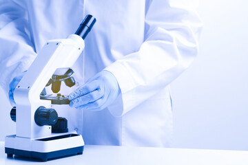 Scientist working with microscope in laboratory, closeup