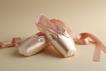 Pair of beautiful pointe shoes on beige background