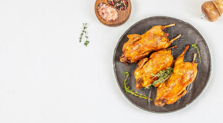 Delicious fried quail with herbs on plate on a white background top view. copy space