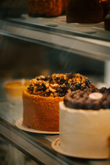 Delicious cakes displayed in a pastry shop showcasing a variety of flavors during a bustling afternoon