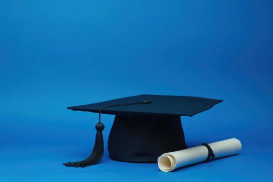 graduation cap and diploma on blue background