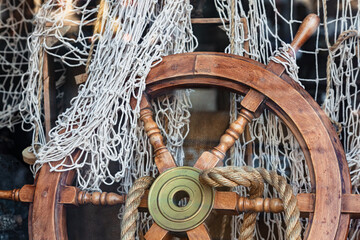 Decorative wooden steering wheel with fishing net and rope.
