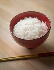Red japanese lacquer bowl filled with boiled white rice on the table.