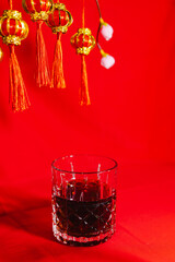Chinese New Year Concept, Whiskey Glass On Red Background.