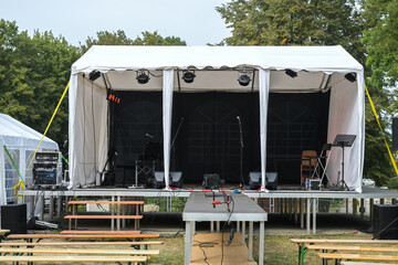 Open-air stage and wooden benches for the audience under construction for a music festival in the...