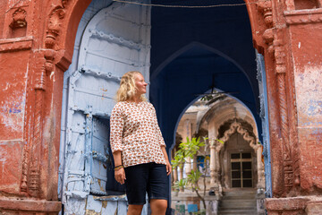 Young blonde woman discovering traditional blue houses of Jodhpur old town in Rajasthan, India