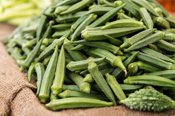 Green okra pods displayed on sackcloth on the Indian street market