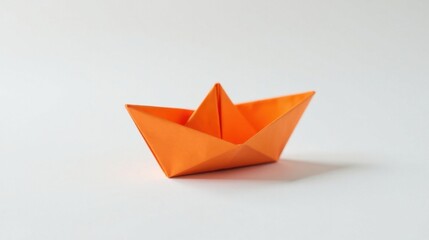 Obraz premium A Small Orange Paper Boat on a Plain White Background, a Simple Craft Item Representing Childhood Innocence and Creative Imagination