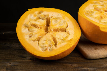 ripe orange pumpkin with seeds cut into pieces