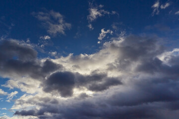 Obraz premium The sky with fluffy white-gray clouds bathed in the gentle light of the day.