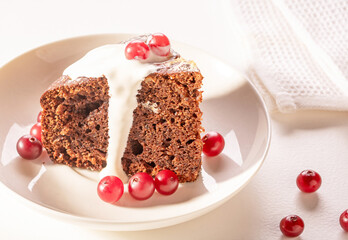 A piece of chocolate cake with cranberries and cream sauce