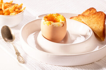 Soft-boiled egg, croutons and French fries on the kitchen table