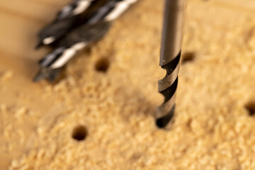 pine board that is drilled with steel drills