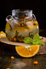 tea with orange and ripe sea buckthorn berries