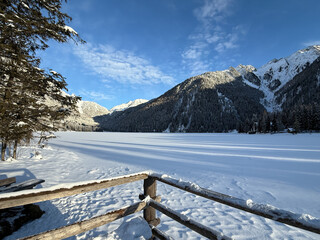Fototapeta premium Lake Anterselva, Italy. Amazing view of the famous lake Anterselva in winter time. Frozen and snow-covered alpine lake. Alpine contest. Picturesque mountain lake at Dolomites. Wonderful nature contest
