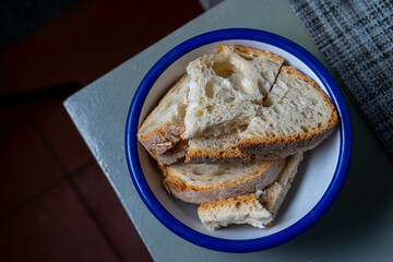 A bowl of sliced Alentejo bread, ready to be added to the traditional Portuguese tomato soup, showcasing rustic and authentic flavors.