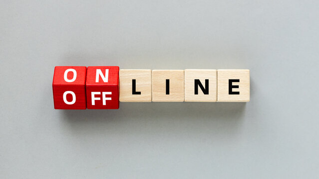 Online and Offline. Concept of accessibility in business. Red wooden cubes change the word Online to Offline. Gray background, Flat lay, copy space