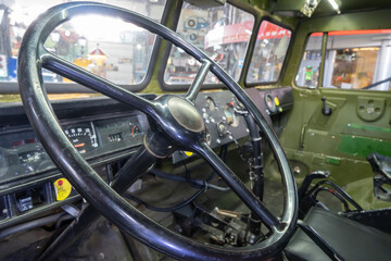 Steering wheel of vintage car close-up. Interior of old-fashioned classic automobile. Good condition of control transportation classical style. Dashboard is vehicle part. Steering wheel machine.