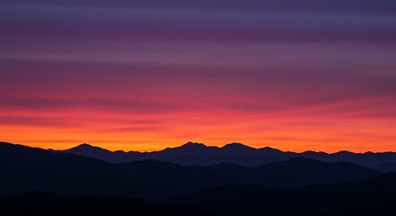 Obraz premium Vibrant colorful gradient sky over silhouetted mountain range at sunset, concept for travel inspiration, nature exploration and serene landscape photography