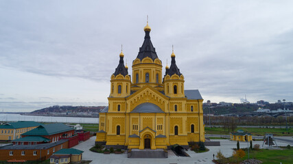 Fototapeta premium Large yellow church with a steeple and a small building next to it