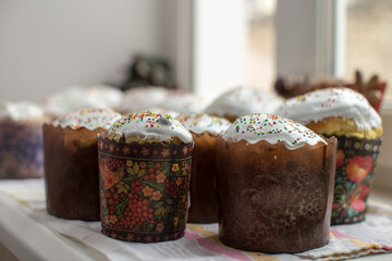 Close-up view of several Easter cakes, likely kulich, arranged on a white surface.